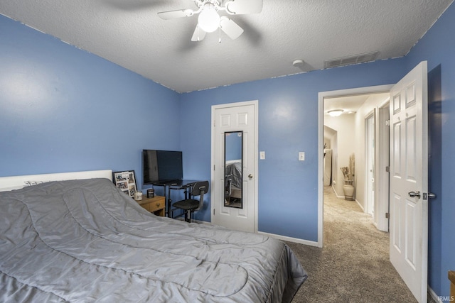 carpeted bedroom with ceiling fan and a textured ceiling