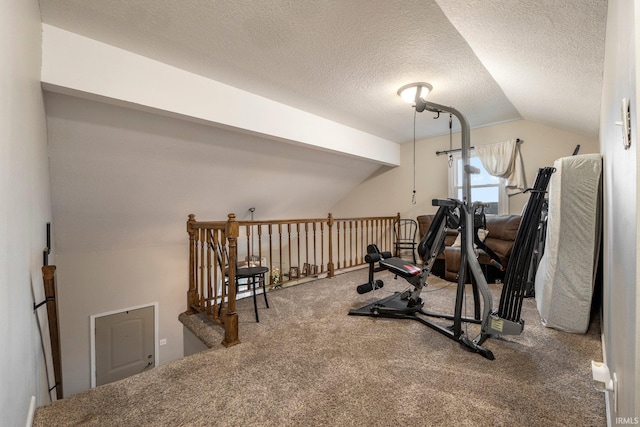 workout room featuring a textured ceiling, carpet, and vaulted ceiling