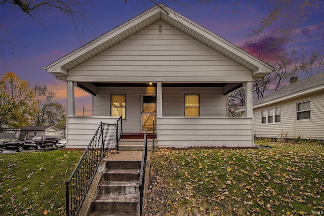 bungalow-style house with a lawn and a porch