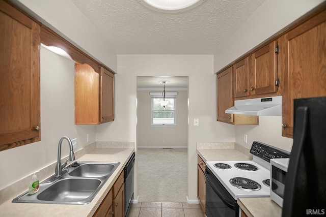 kitchen with a textured ceiling, sink, black appliances, and decorative light fixtures