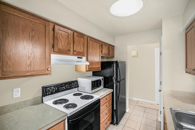 kitchen with light tile patterned floors, white appliances, a textured ceiling, and sink