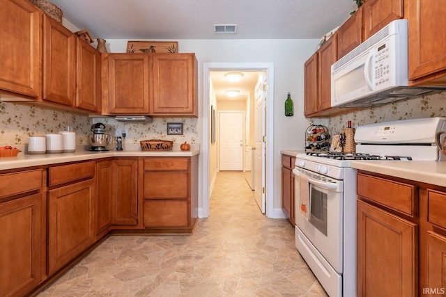 kitchen with a textured ceiling and white appliances