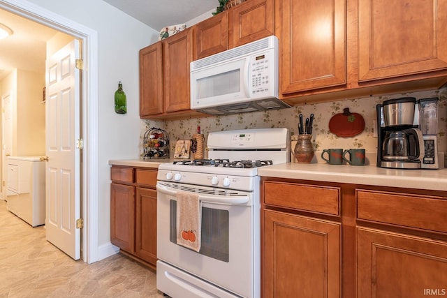 kitchen featuring washer / clothes dryer and white appliances