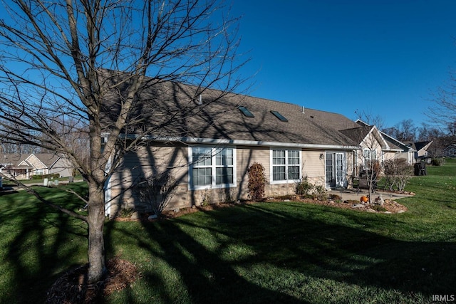 rear view of property featuring a lawn and a patio