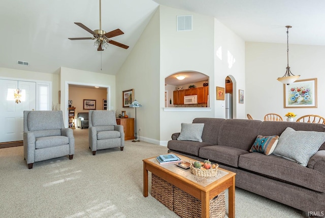 carpeted living room with high vaulted ceiling and ceiling fan