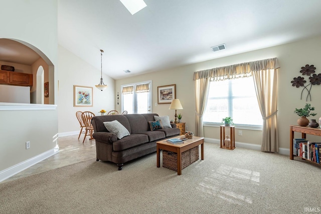 carpeted living room with a healthy amount of sunlight and lofted ceiling