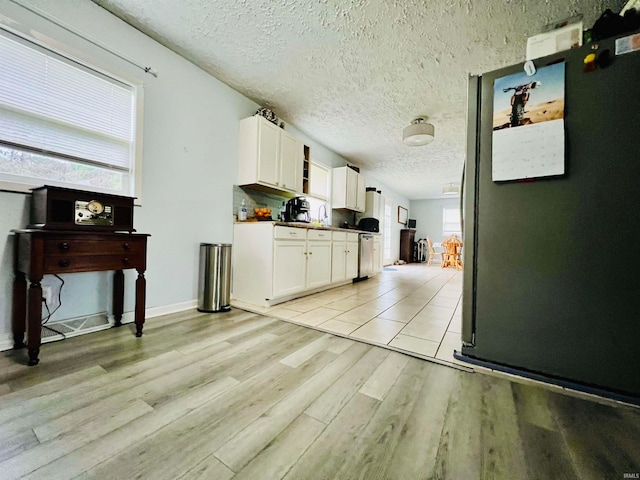 kitchen featuring white cabinetry, a textured ceiling, and light hardwood / wood-style flooring