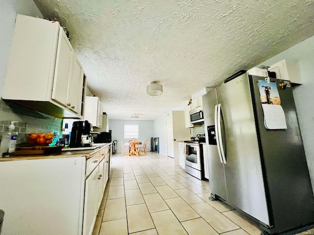 kitchen featuring white cabinetry, stainless steel appliances, and a textured ceiling