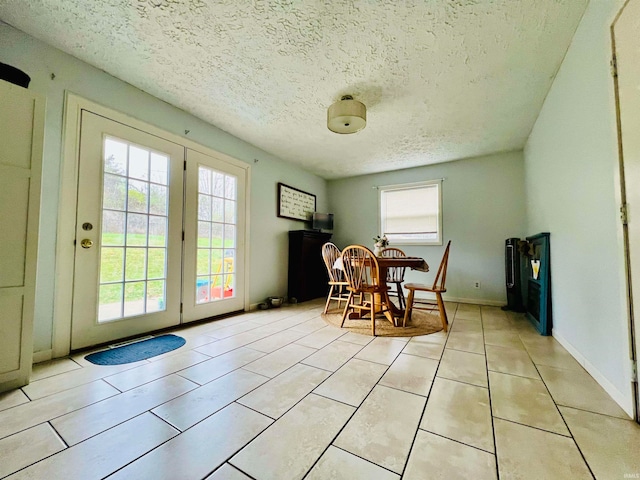 tiled dining space with a textured ceiling