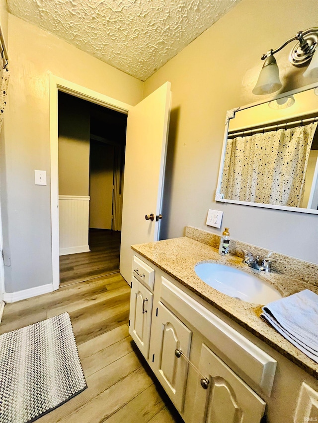 bathroom with vanity, a textured ceiling, hardwood / wood-style flooring, and walk in shower