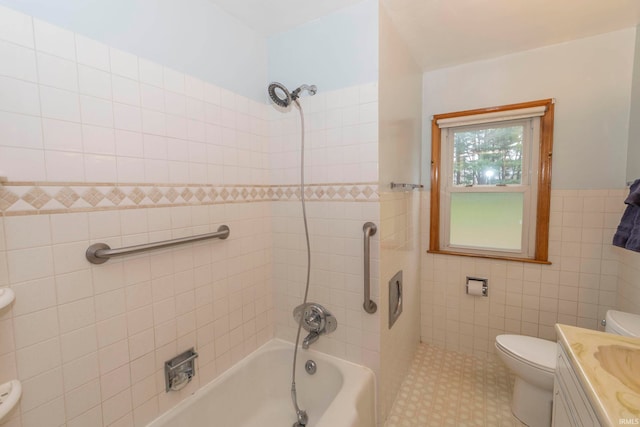 full bathroom with vanity, toilet, tile walls, and tiled shower / bath