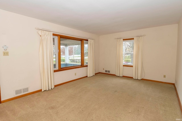 unfurnished room featuring light carpet