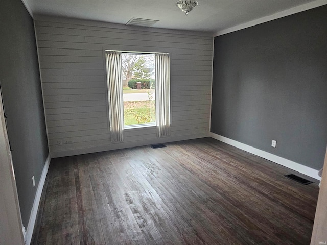 empty room featuring dark hardwood / wood-style floors and wood walls