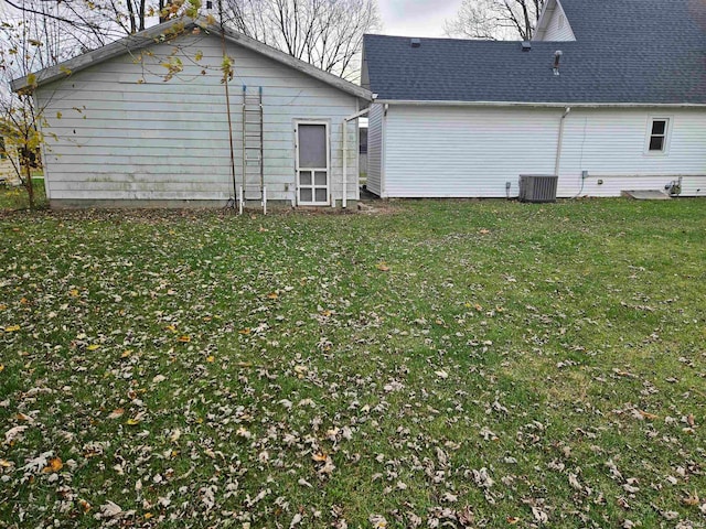 back of property featuring central AC and a lawn