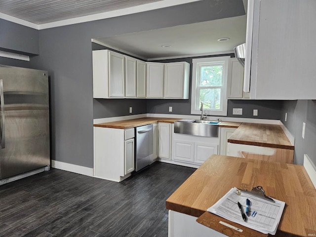 kitchen featuring crown molding, sink, appliances with stainless steel finishes, butcher block countertops, and white cabinetry