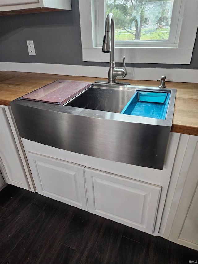 details with butcher block counters, white cabinetry, sink, and dark hardwood / wood-style floors