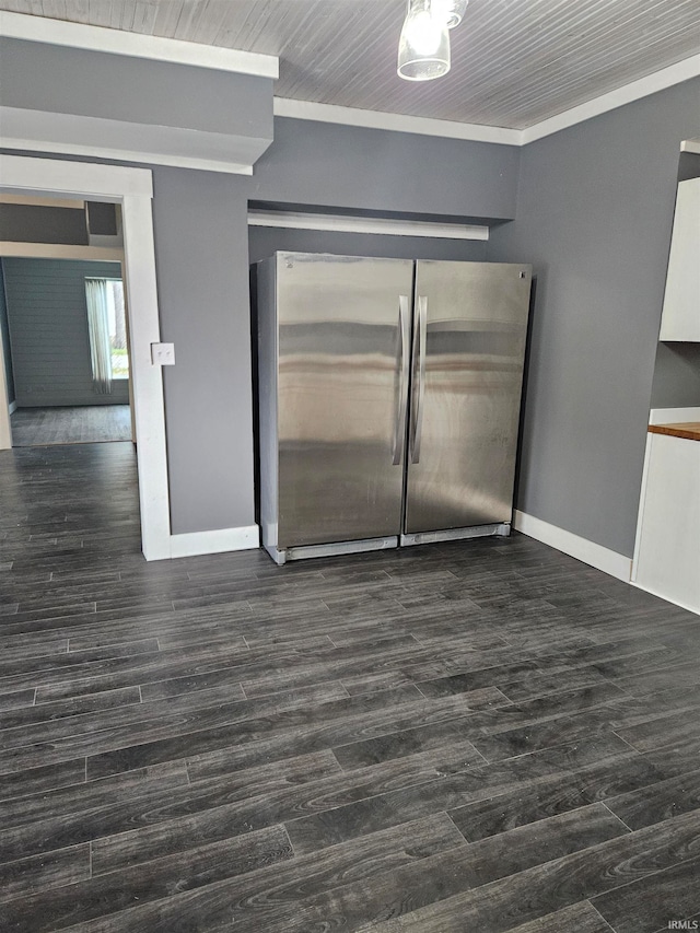 spare room with ornamental molding and dark wood-type flooring