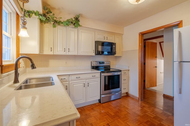 kitchen with sink, white refrigerator, decorative light fixtures, light parquet flooring, and stainless steel electric range