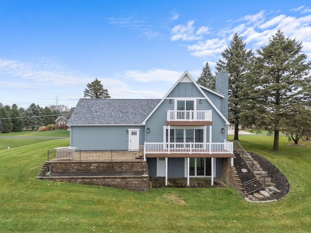 back of house with a yard, a balcony, and a wooden deck