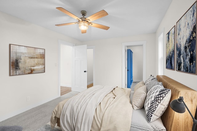 carpeted bedroom with ceiling fan and ensuite bathroom