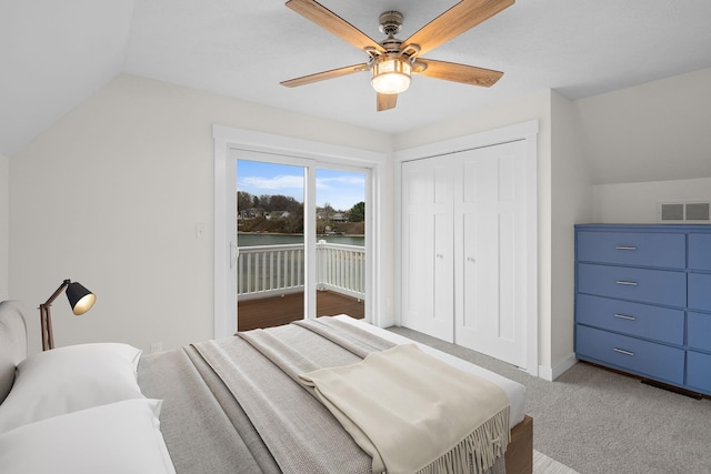 carpeted bedroom featuring access to exterior, a closet, vaulted ceiling, and ceiling fan