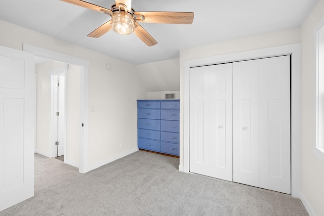 unfurnished bedroom featuring a closet, vaulted ceiling, ceiling fan, and light colored carpet