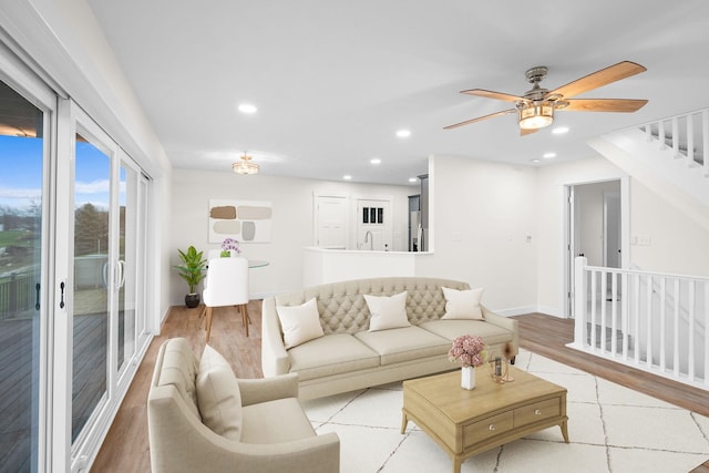 living room with ceiling fan, light wood-type flooring, and sink