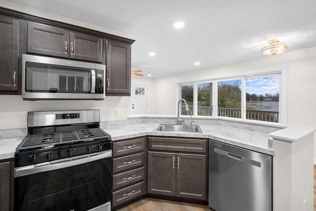 kitchen featuring ceiling fan, dark brown cabinetry, sink, and appliances with stainless steel finishes