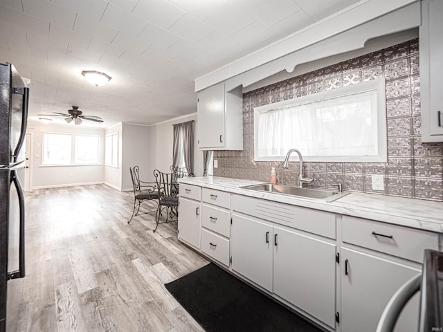 kitchen with ceiling fan, a healthy amount of sunlight, sink, and light hardwood / wood-style flooring