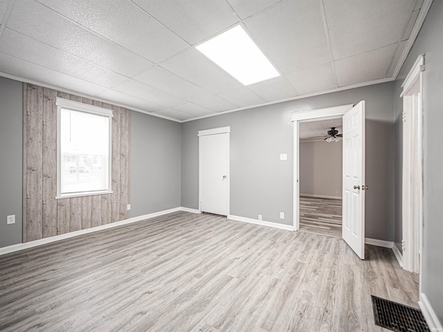 unfurnished room with light wood-type flooring, ceiling fan, and ornamental molding