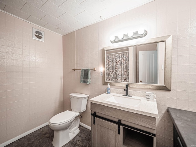 bathroom featuring vanity, tile walls, and toilet