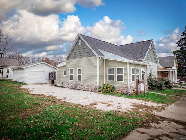 view of home's exterior featuring a garage, an outdoor structure, and a lawn