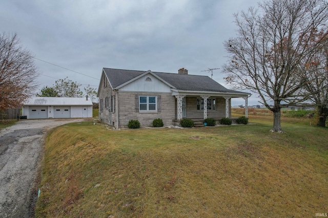 view of front facade featuring an outbuilding, a porch, a garage, and a front yard