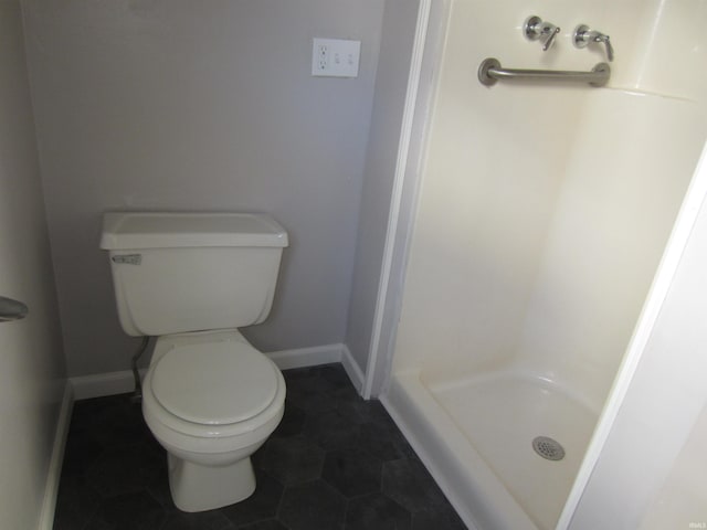 bathroom featuring a shower, tile patterned floors, and toilet