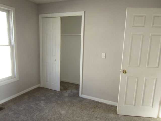 unfurnished bedroom with carpet flooring and a closet