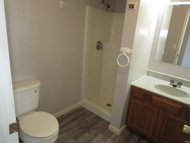 bathroom featuring a shower, hardwood / wood-style floors, vanity, and toilet