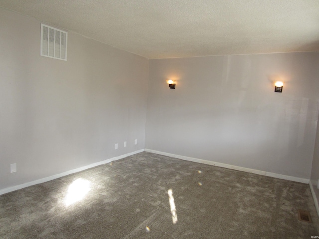 carpeted empty room with a textured ceiling