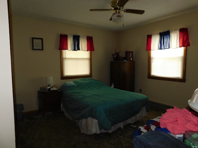 bedroom featuring a baseboard heating unit, ceiling fan, and baseboards