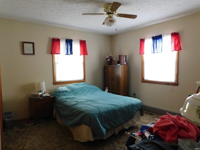 bedroom featuring multiple windows, a ceiling fan, baseboard heating, and a textured ceiling