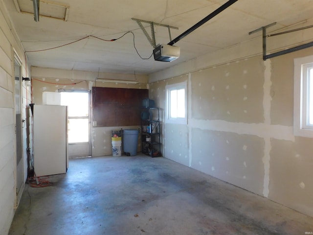 garage with freestanding refrigerator and a garage door opener