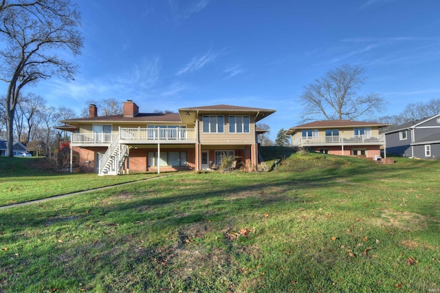 rear view of house featuring a deck and a lawn