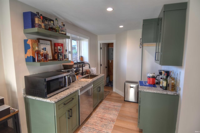 kitchen featuring green cabinets, light wood-type flooring, sink, and appliances with stainless steel finishes