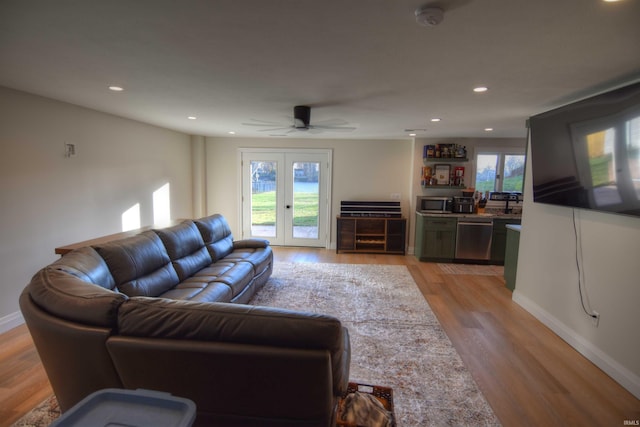 living room with ceiling fan, light hardwood / wood-style flooring, and french doors