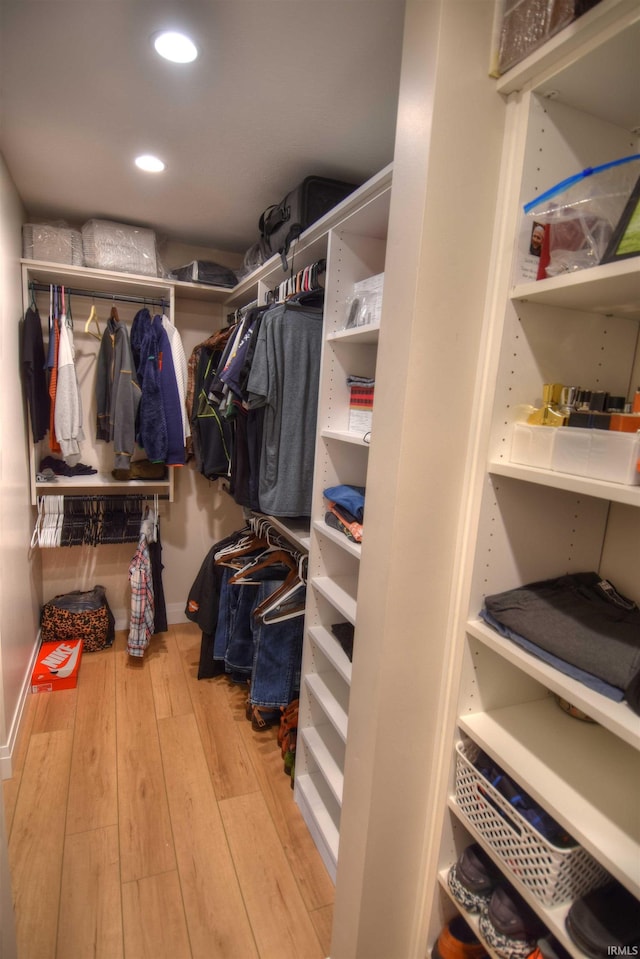 walk in closet with light hardwood / wood-style flooring