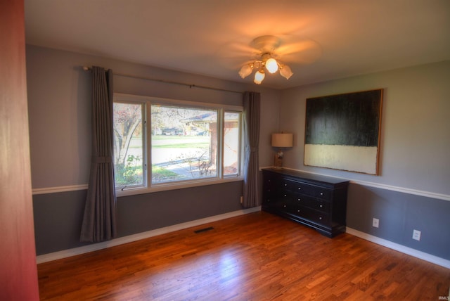 empty room featuring ceiling fan and dark wood-type flooring