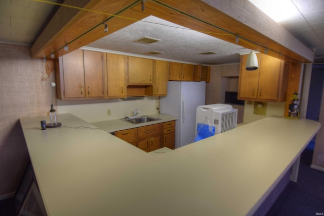 kitchen featuring kitchen peninsula, sink, and white fridge