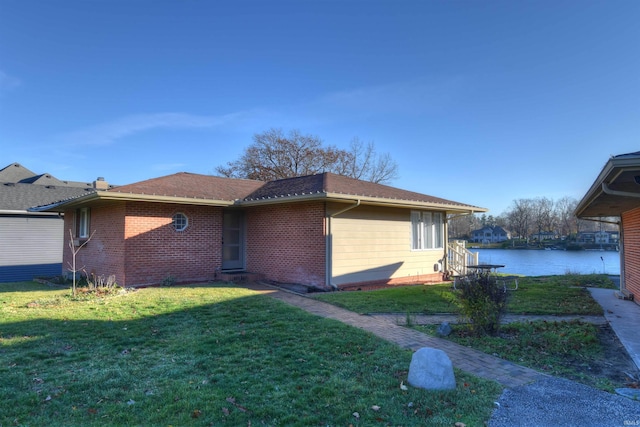 ranch-style home with a water view and a front lawn