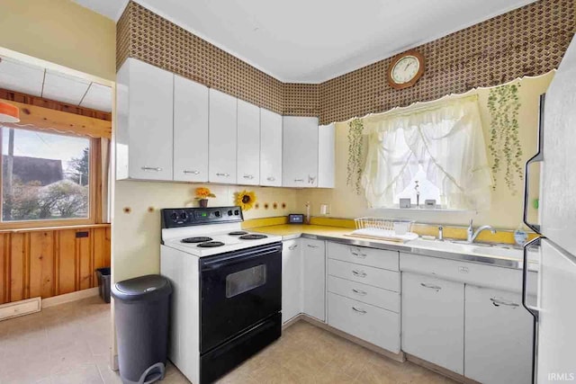 kitchen with white range with electric stovetop, white cabinetry, and sink