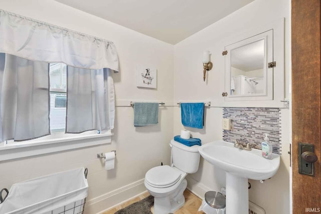 bathroom featuring tasteful backsplash and toilet