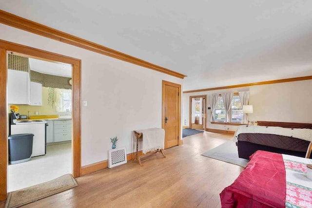 bedroom featuring ornamental molding and light hardwood / wood-style flooring